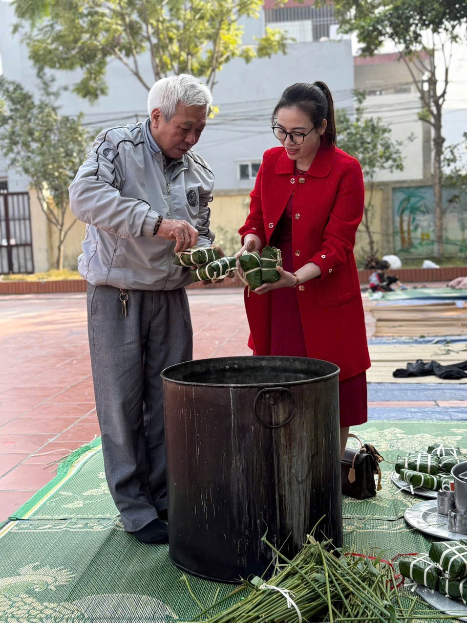Cô Nguyễn Thị Xuyến- Hiệu trưởng nhà trường cùng bác phụ huynh đang giúp các cô giáo trong “ Lễ hội bánh trưng”